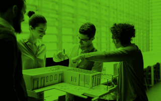 Group of young architects with model of a house standing in office, talking.